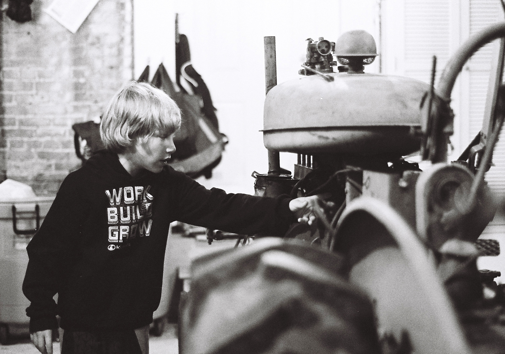 Archie with the tractor he is rebuilding with his dad.