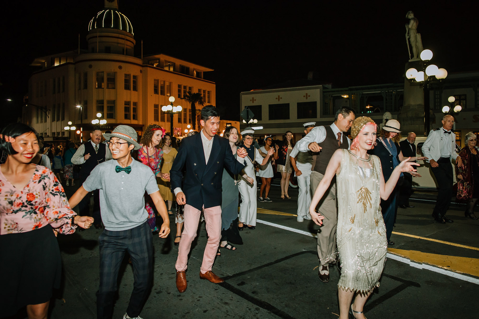 Art Deco Festival party goers dancing in the street at night