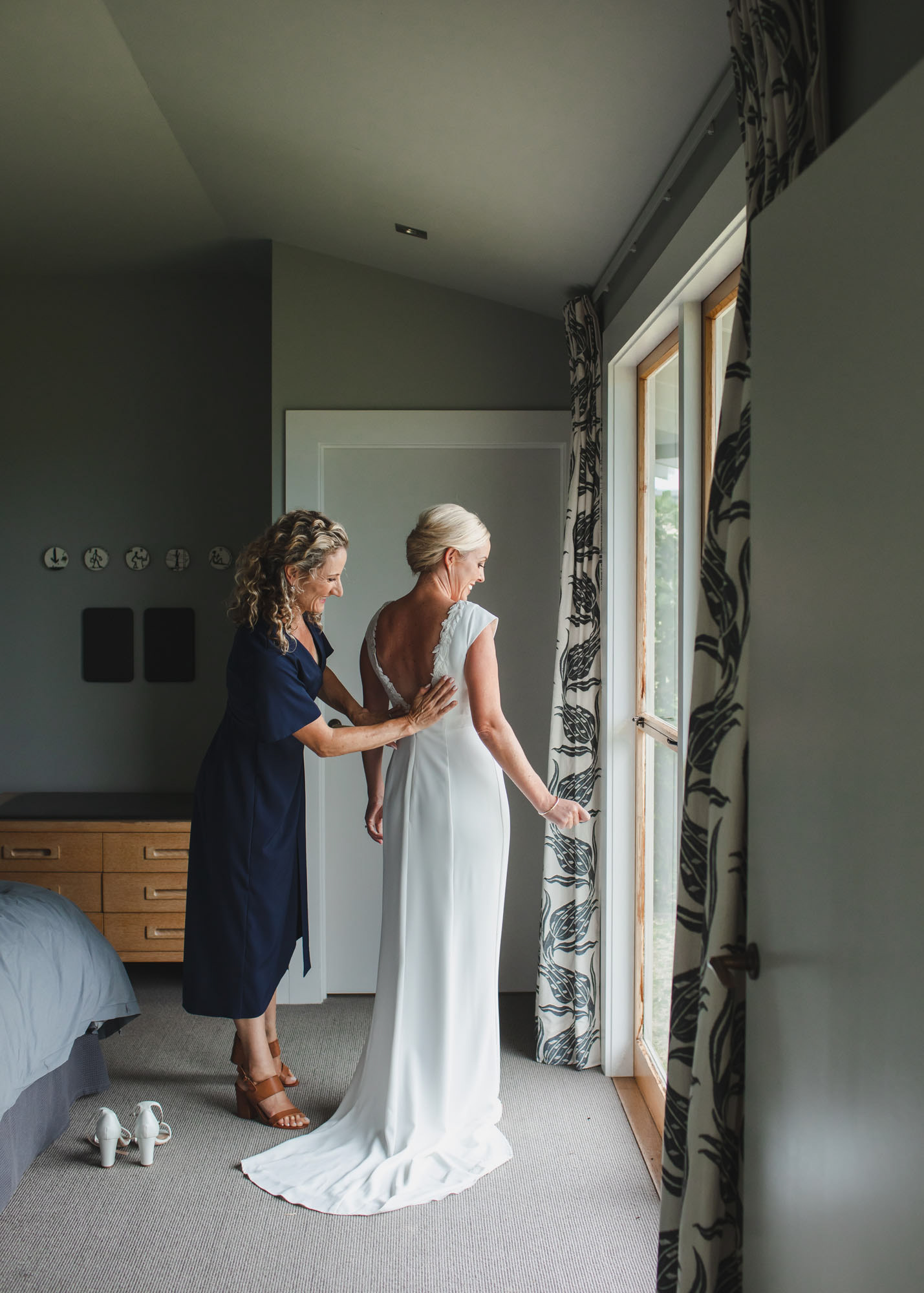 Bride Hannah with her bridesmaid admiring her wedding dress while getting ready