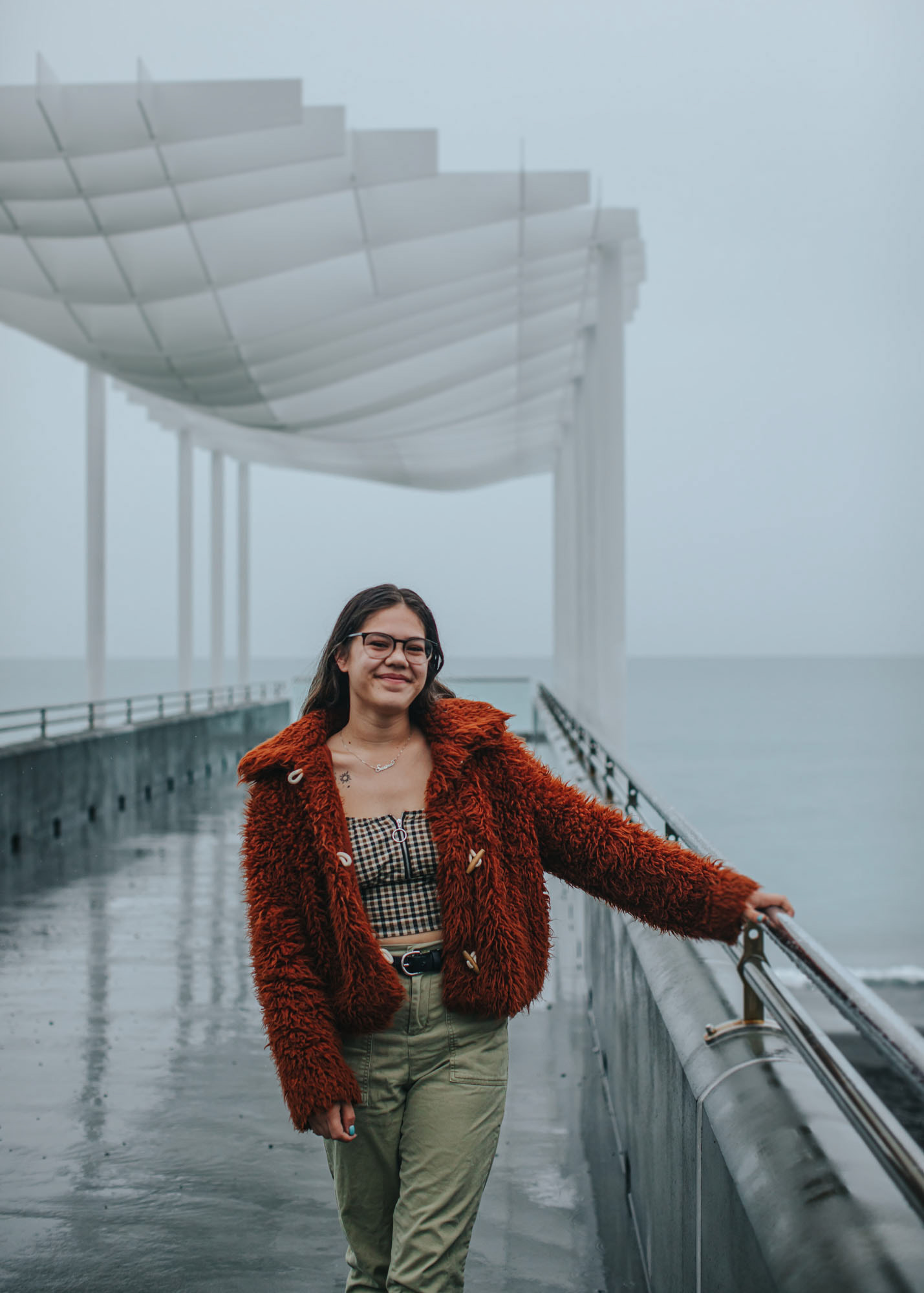 Campaign photography involving youth having a voice. Young woman walking in the rain on Napier's viewing platform