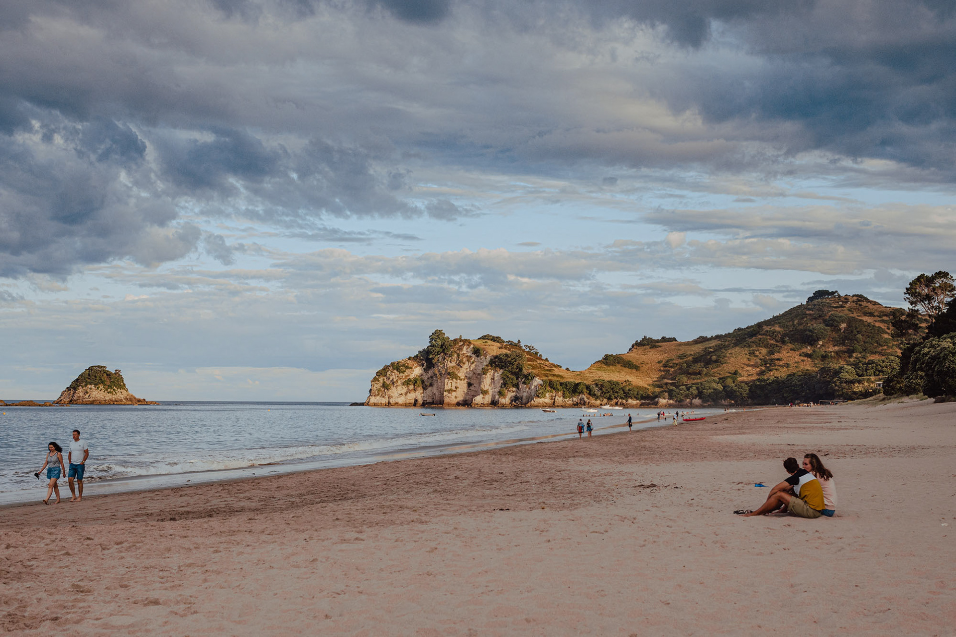Hahei beach at dusk - people enjoying the beach and view