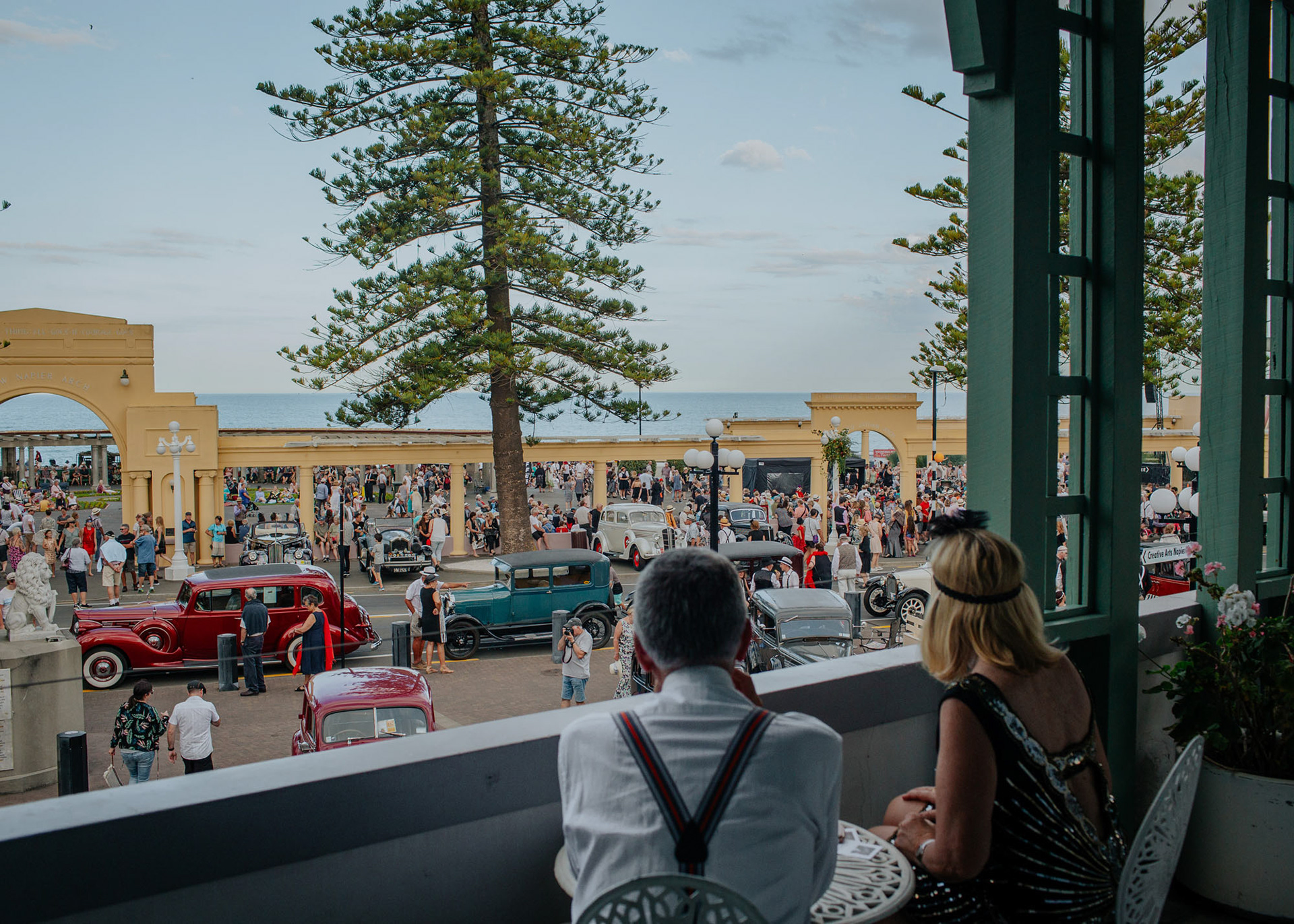 View from the Art Deco Masonic Hotel balcony looking across to the Soundshell with throngs of people and vintage cars.