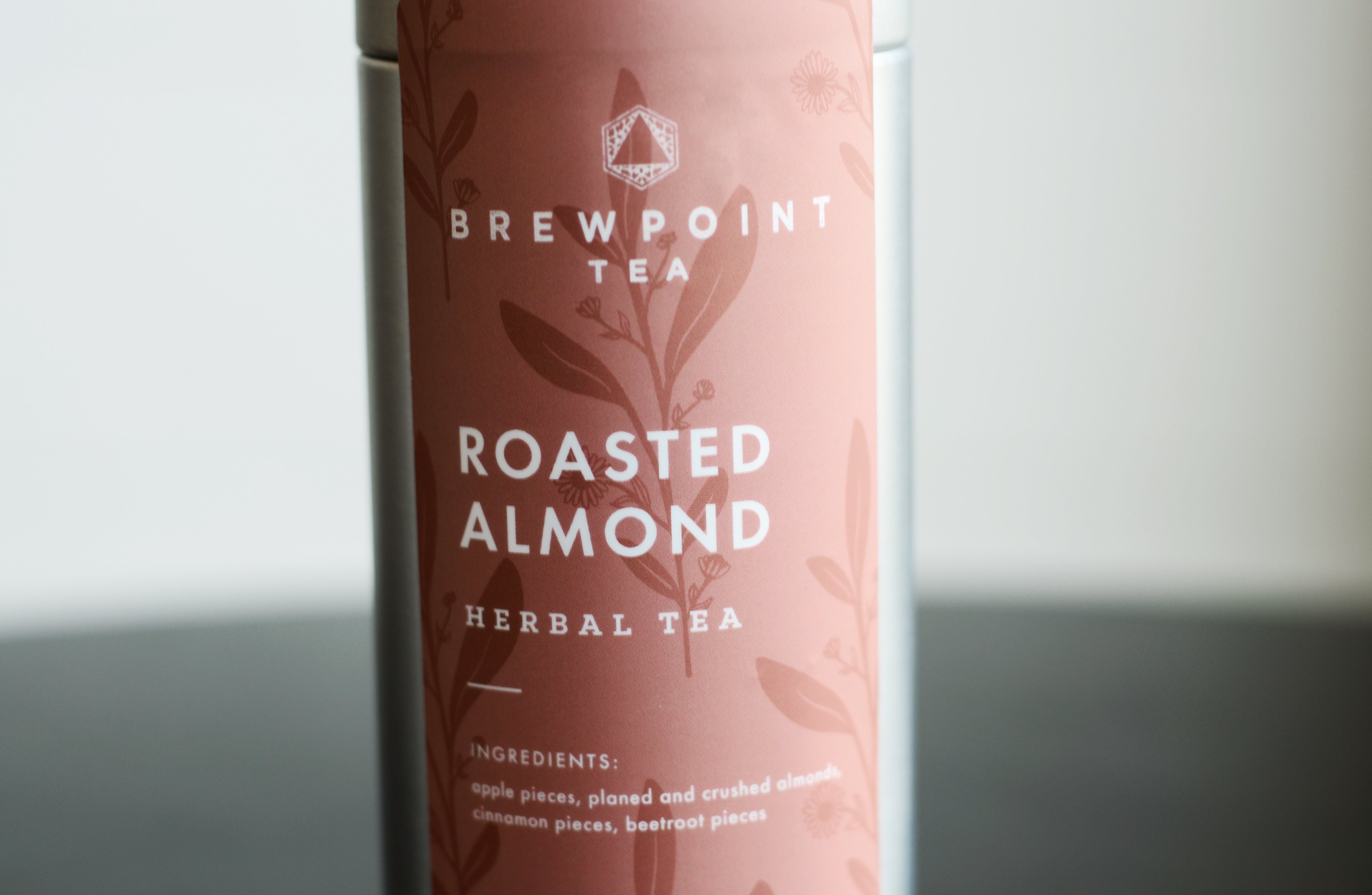 Label design for Brewpoint Coffee's roasted almond herbal tea packaging.