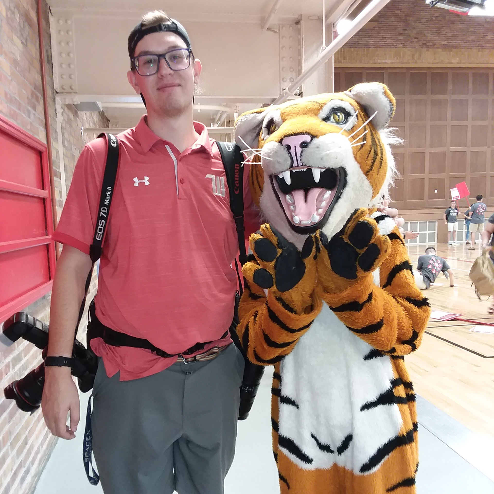 University Communications Photojournalist Trent Sprague poses with Ezry The Tiger before photographing members of the class of 2023 meeting with their orientation assistants on Aug 15, 2019 as part of Welcome Week. (Meghan Nadzam/Wittenberg University)