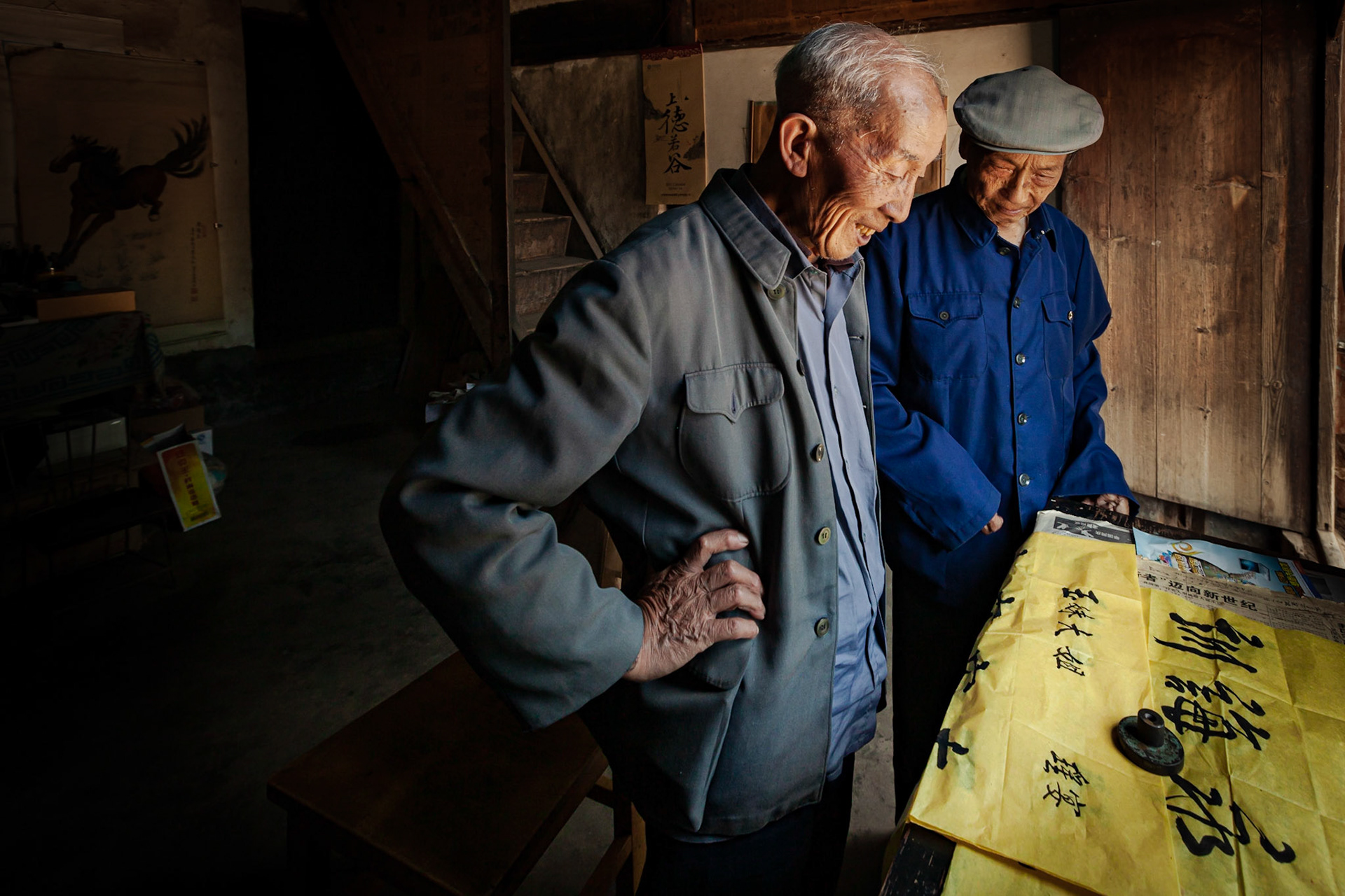 A Chinese Calligrapher making signs using traditional calligraphy in his shop in Shaxi, Yunnan Province, China.