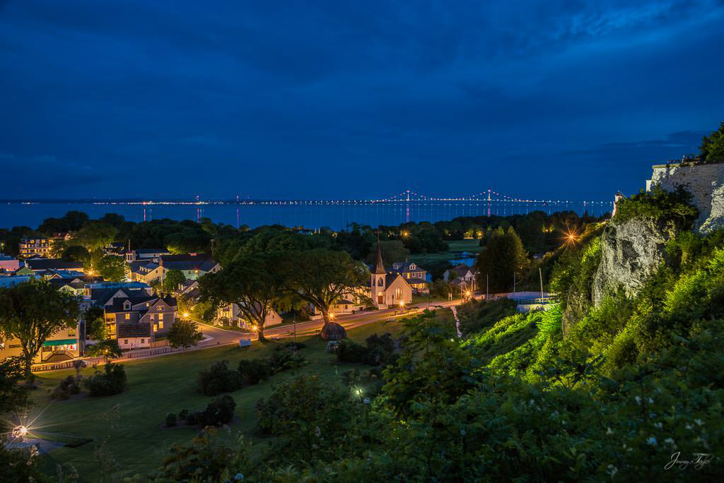 Mackinac Island at night, beautiful view from high above. Mackinac Bridge in a distance.