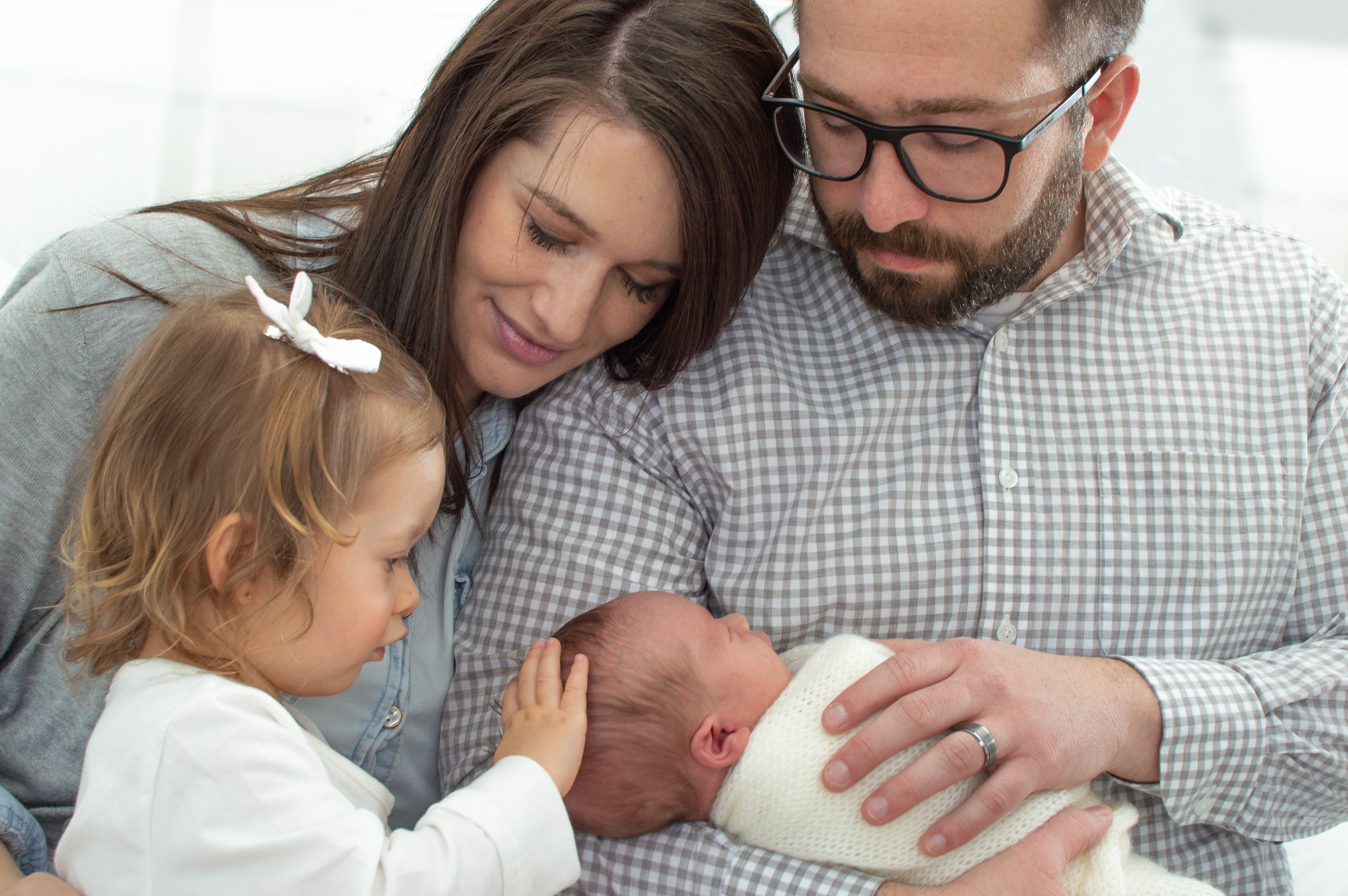 Family with toddler holding newborn baby
