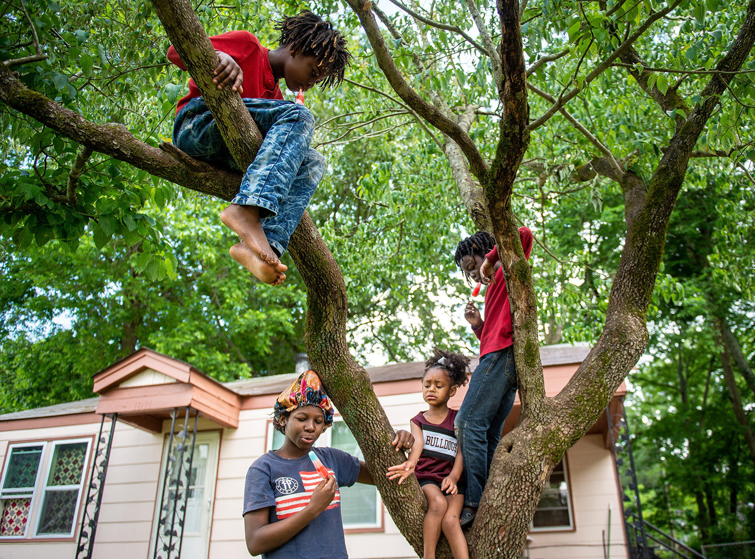 Clockwise from top left, Kenderrick Heath, 10, Kentravious Heath, 9, Lailah Holmes, 3, and Yanna Heath, 12, enjoy popsicles outside their home during warm weather Thursday, May 21, 2020, in Southeast Decatur, Ala.