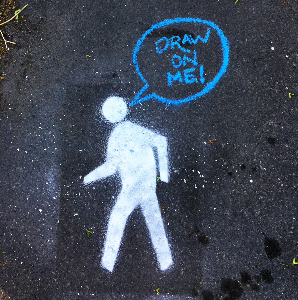 Spray chalk of a walk symbol, with a speech bubble that says "draw on me!"