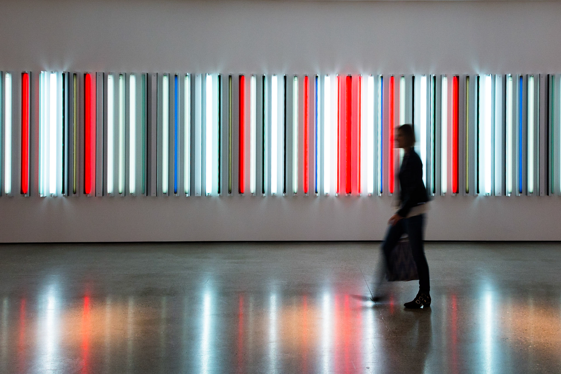 Woman Walking by Neon Artwork with Motion Blur