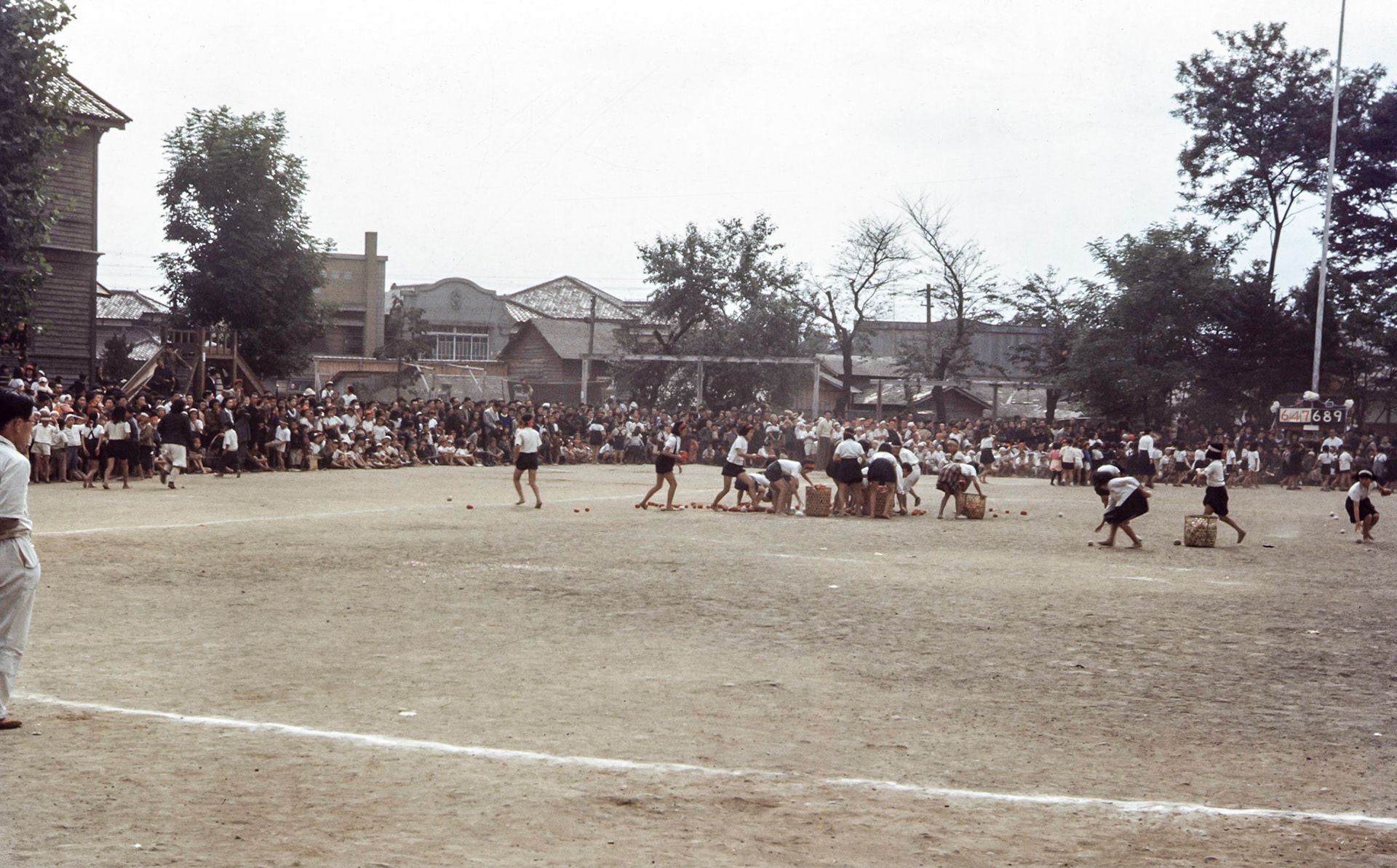 School scene Morioka Sports Day - The game is 玉入れ (tama ire) which means “enter or put the ball in”. Each team has a basket of balls on the ground to throw into another basket stuck to the top of a pole. They still play same game today on Sports Day.