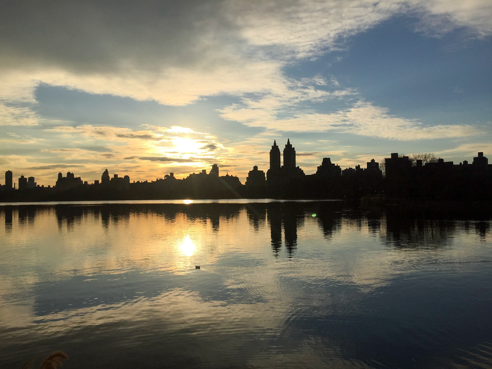 Sun setting over the buildings of the Upper West Side, seen over the Central Park Reservoir
