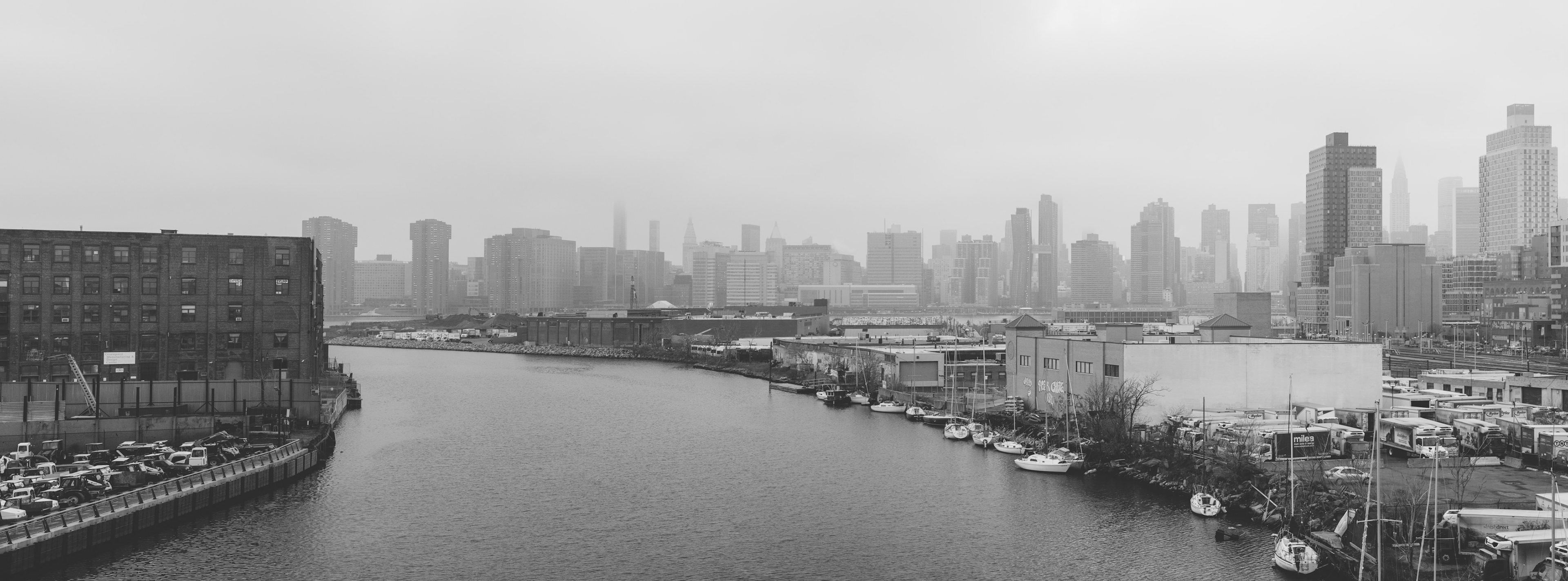 A hazy, cloudy Saturday in New York City.  The Midtown East skyline is viewed from the Pulaski Bridge, connecting Queens (right) with Brooklyn (left).