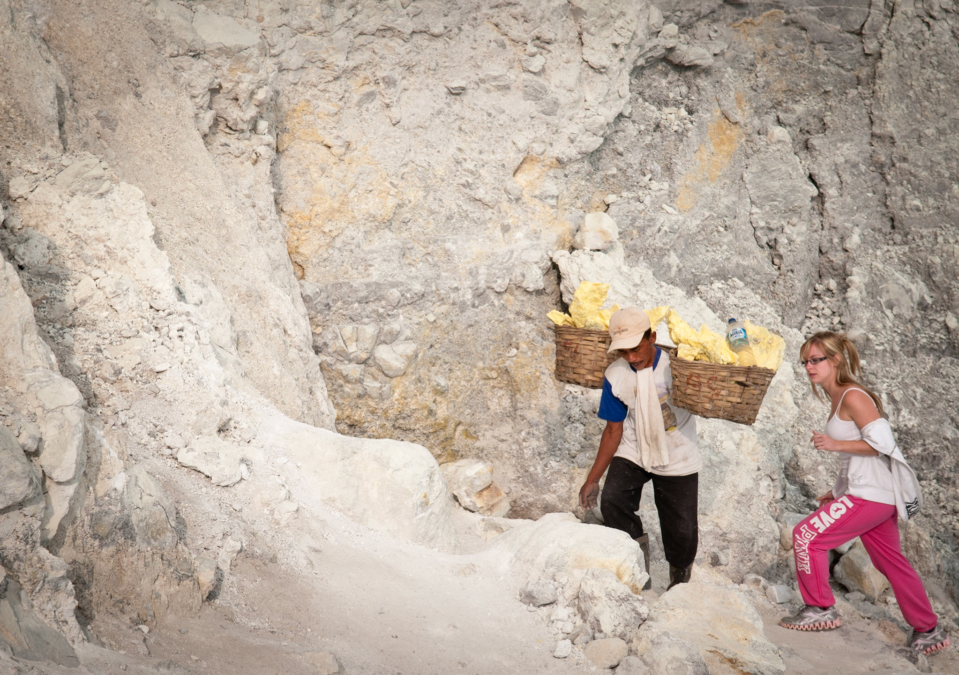 Porter climbing out of the crater with a tourist (Kawah Ijen, Java, Indonesia)
