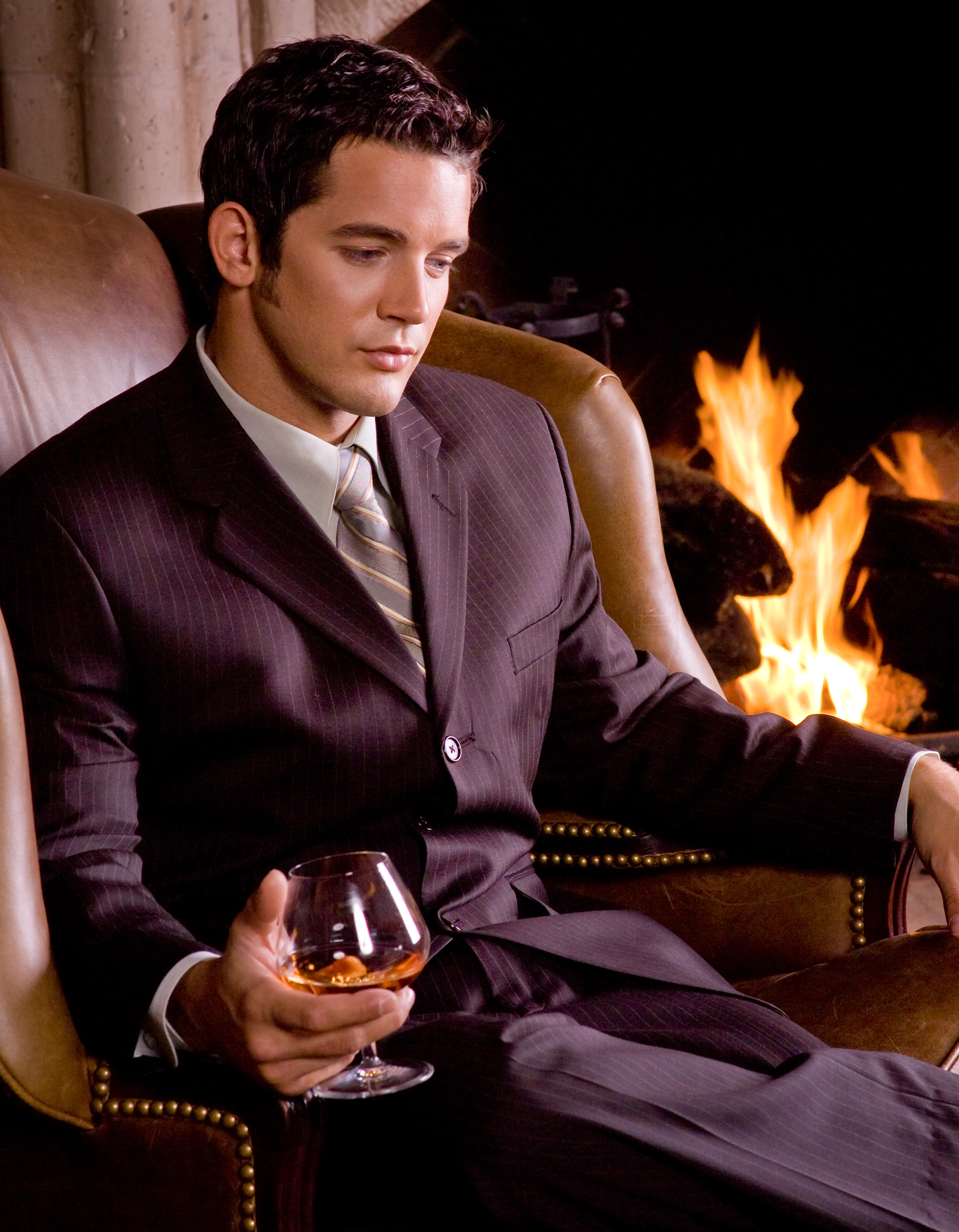 Мужчина с бокалом вина. Мужчина в кресле с бокалом. Мужчина в кресле у камина. Состоятельный мужчина. Красивый богатый мужчина.