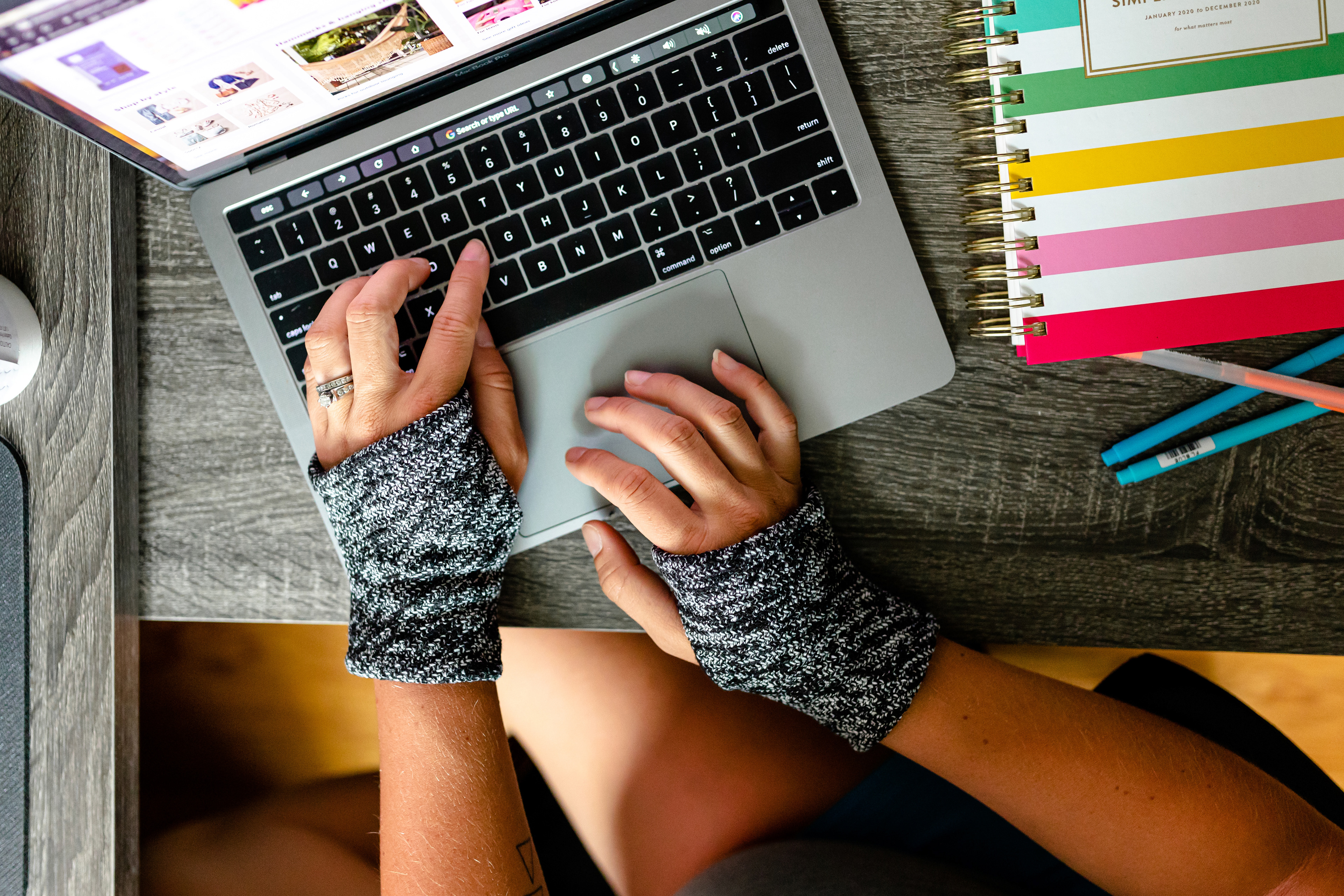 hand warmer computer gloves typing at laptop desk setup